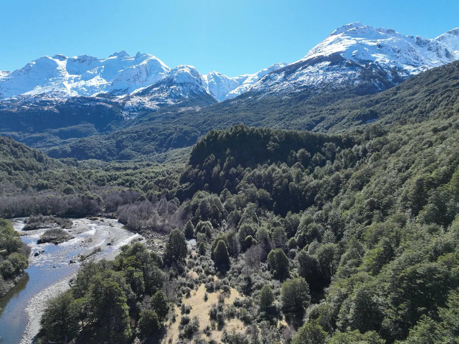 Vista aérea del valle del Río Exploradores, con bosque nativo y cumbres nevadas